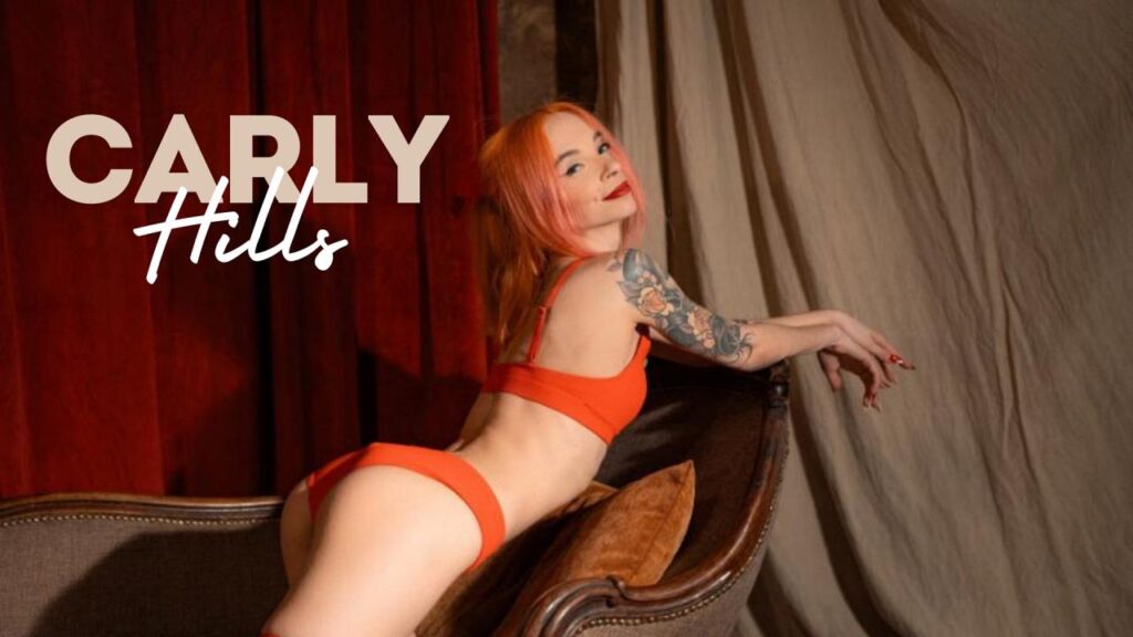 CarlyHills wearing sexy orange bikinis leaning forward on a fancy looking chair looking sensually into the camera